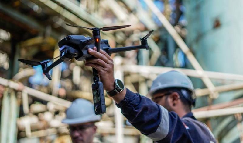 Técnico con casco sostiene un dron con cámara en una obra